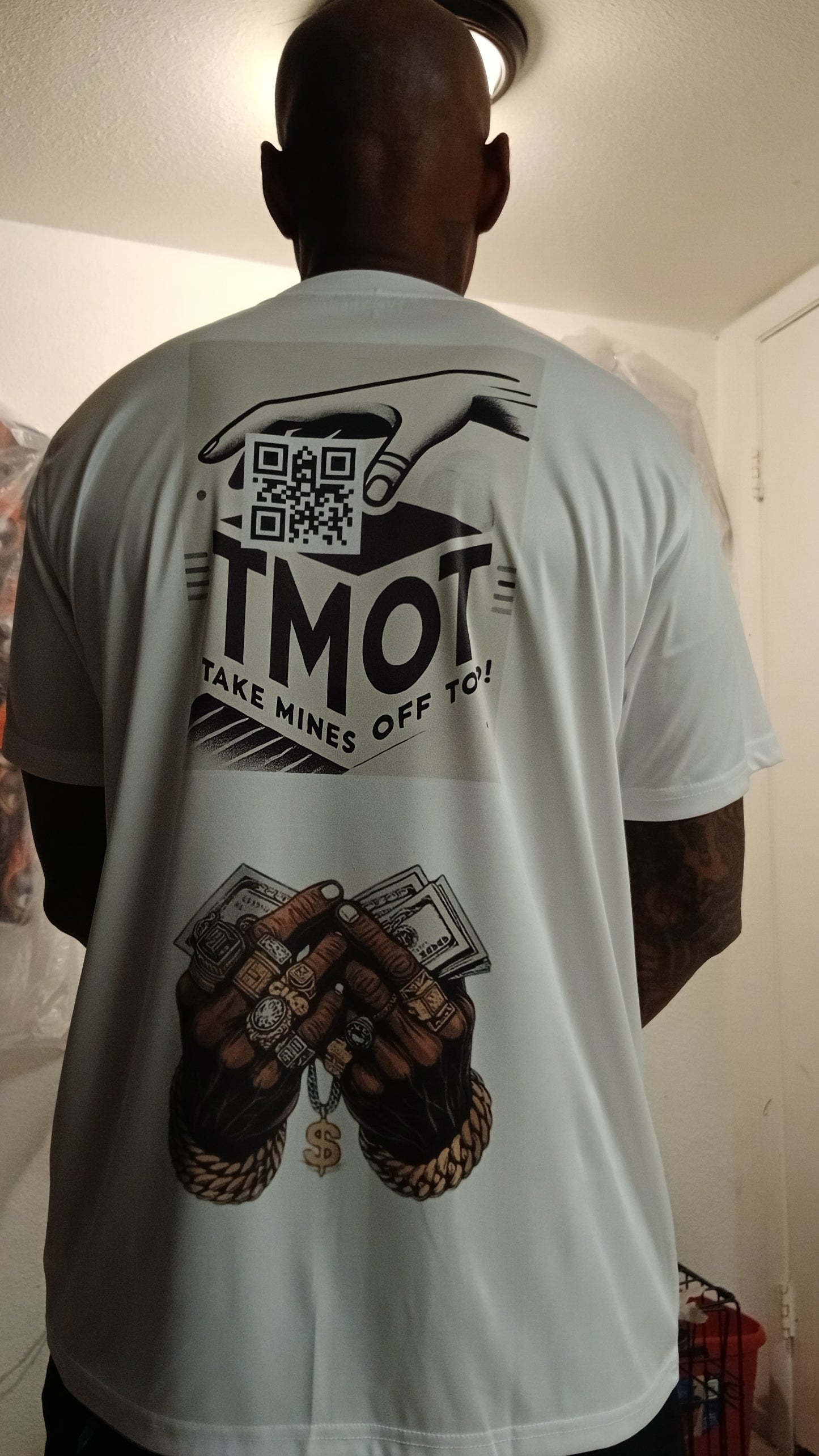 Person wearing a white t-shirt with graphics and text on the back