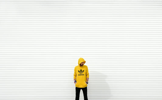 minimalist photography of man standing against white wall