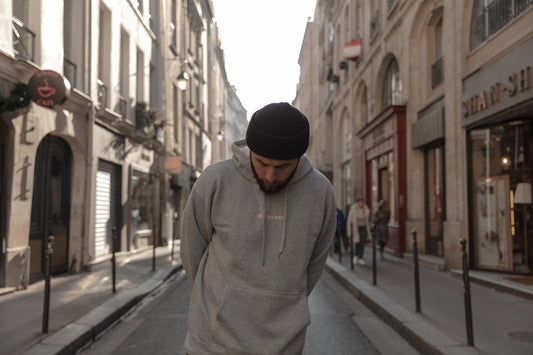 man wearing gray pullover walking on street