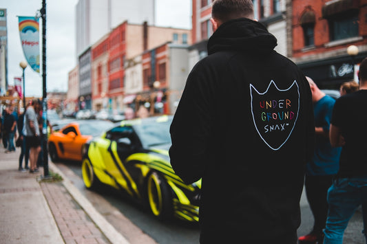 man in black hoodie standing on road during daytime