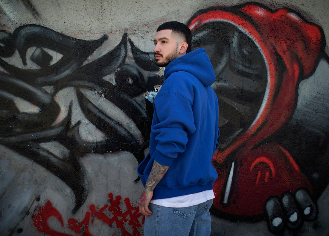 a man standing in front of a graffiti covered wall