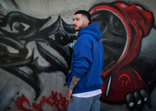 a man standing in front of a graffiti covered wall