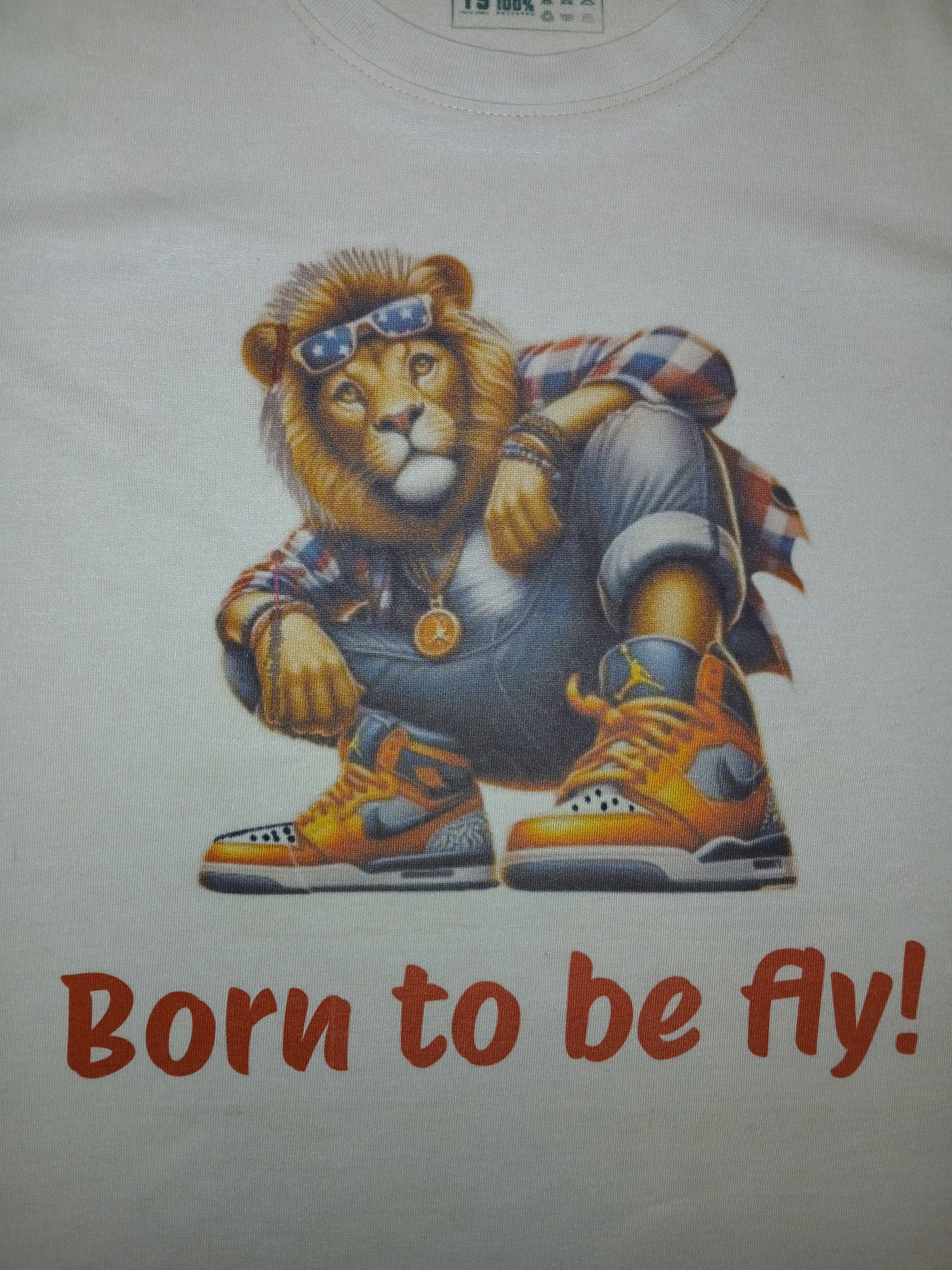 T-shirt with a lion graphic and 'Born to be fly!' text on a white background