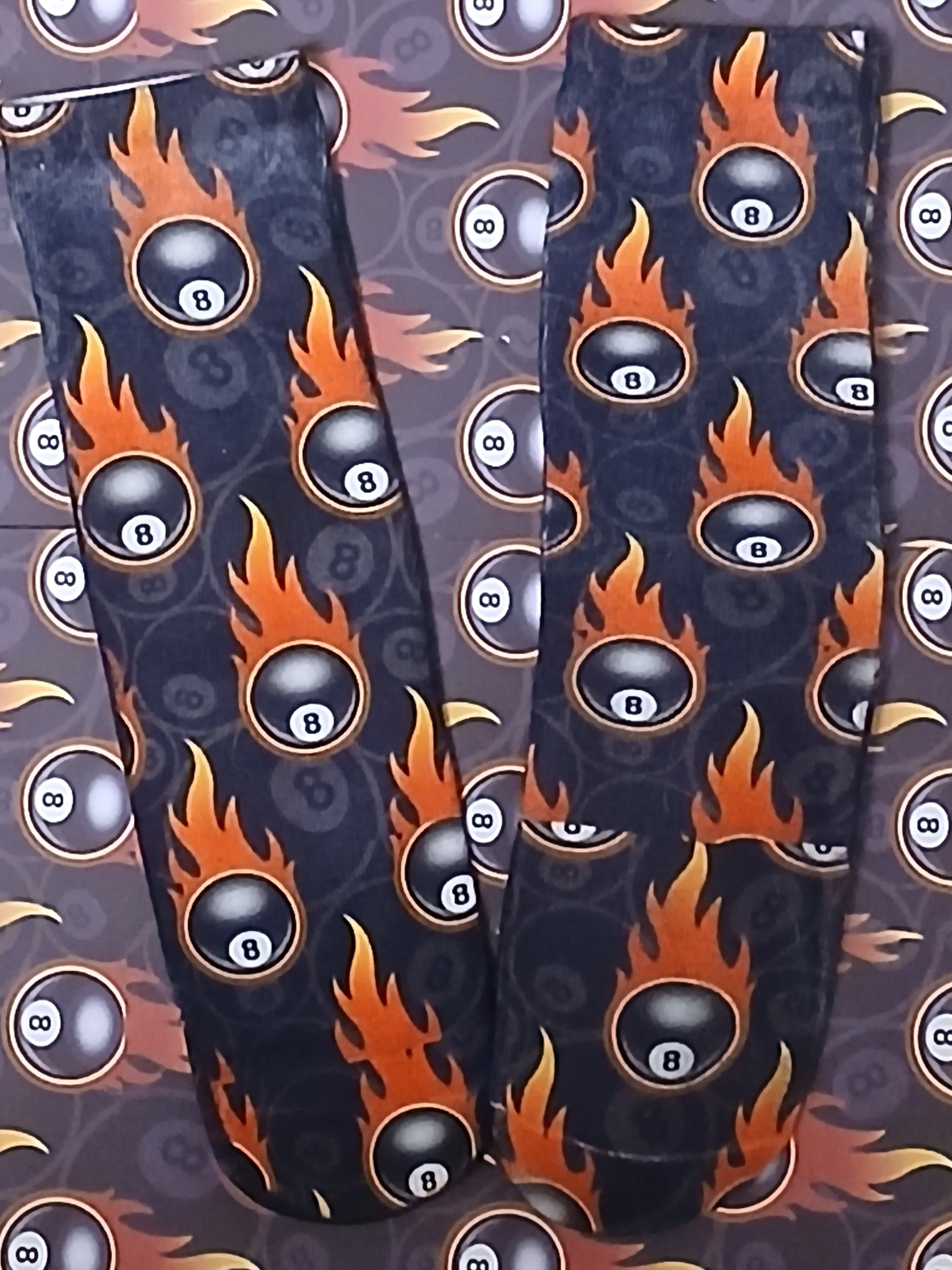 Leggings with 8-ball and flame pattern on a dark background