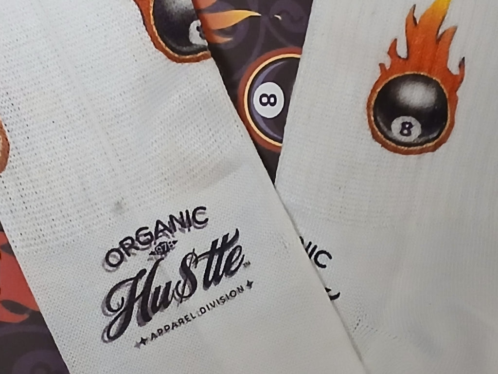 White socks with 'Organic Hustle' branding and a flaming eight-ball design.