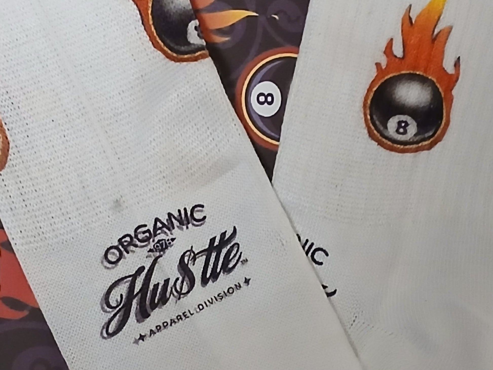 White socks with 'Organic Hustle' branding and a flaming eight-ball design.