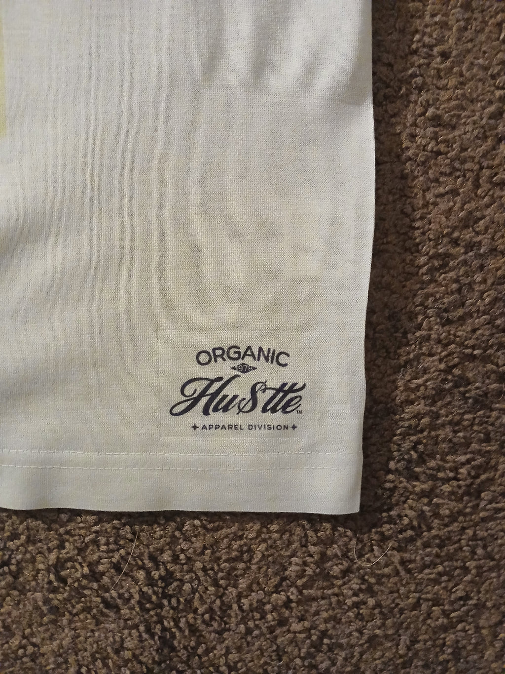 Close-up of a white fabric with 'Organic Hustle' logo on a brown textured surface