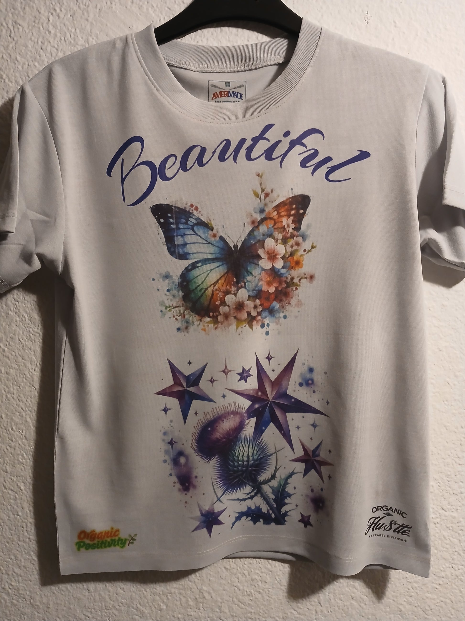 White t-shirt with butterfly and star design on a white background