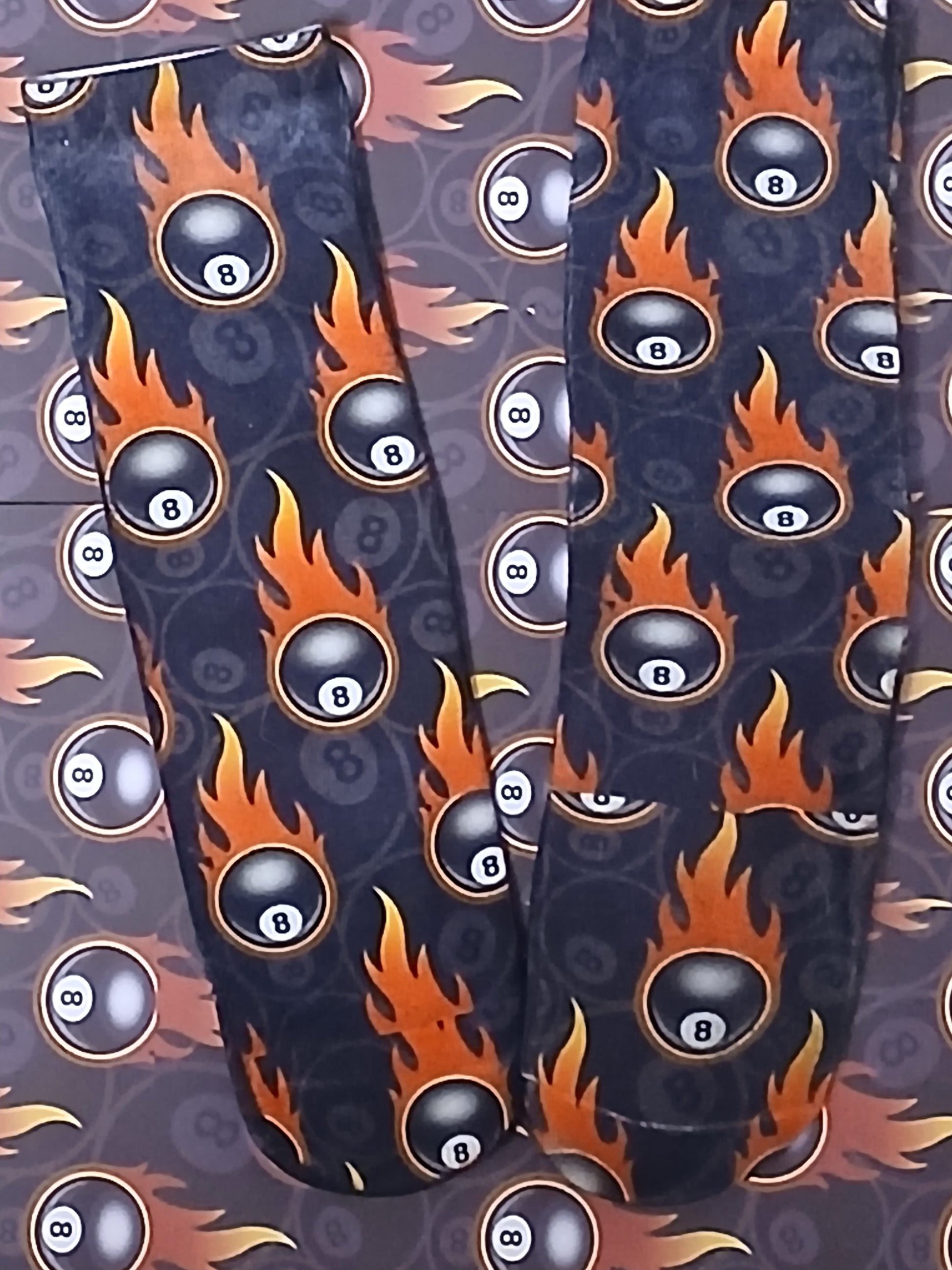 Leggings with 8-ball and flame pattern on a dark background