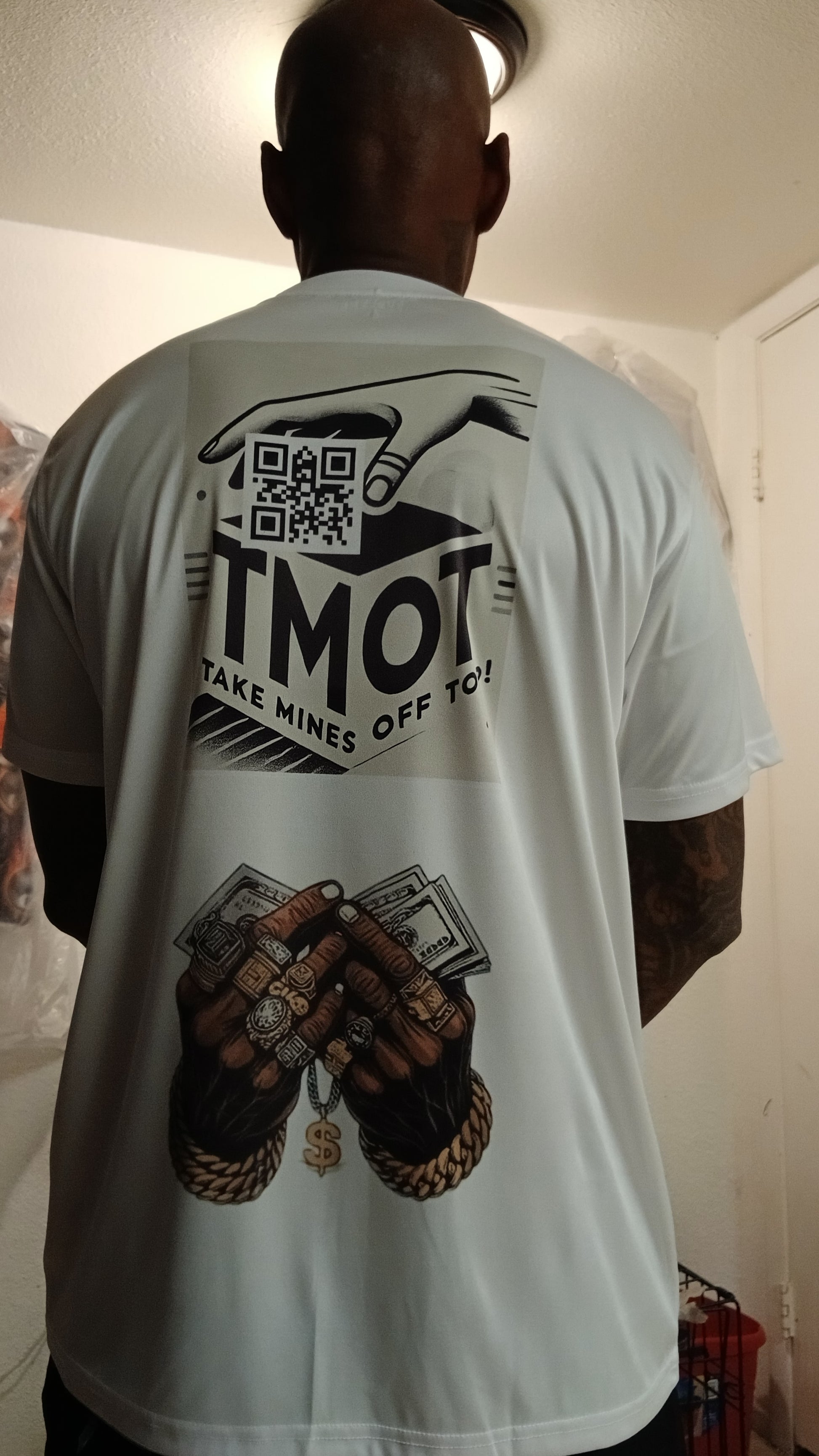 Person wearing a white t-shirt with graphics and text on the back