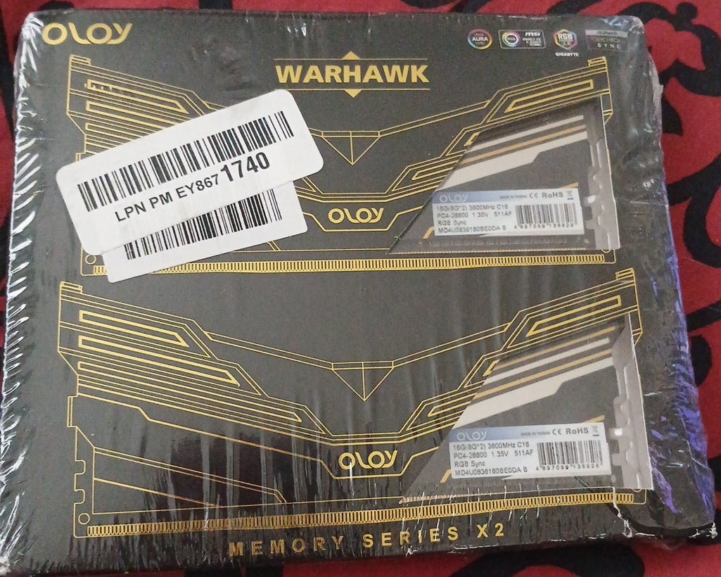 Two OLOV Warhawk computer memory modules in packaging on a red and black patterned surface.