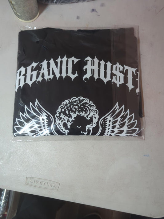 Actual packaged black Guardian Angel tee with white Gothic Organic Hu$tle lettering and winged cherub design