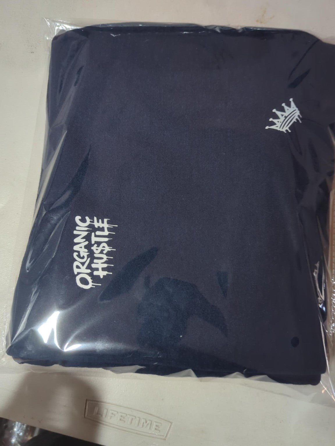 Actual packaged navy blue Organic Hu$tle sweatpants size L, first view