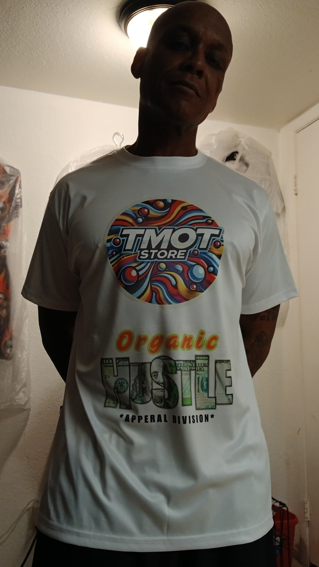 Person wearing a white t-shirt with colorful graphics and text.