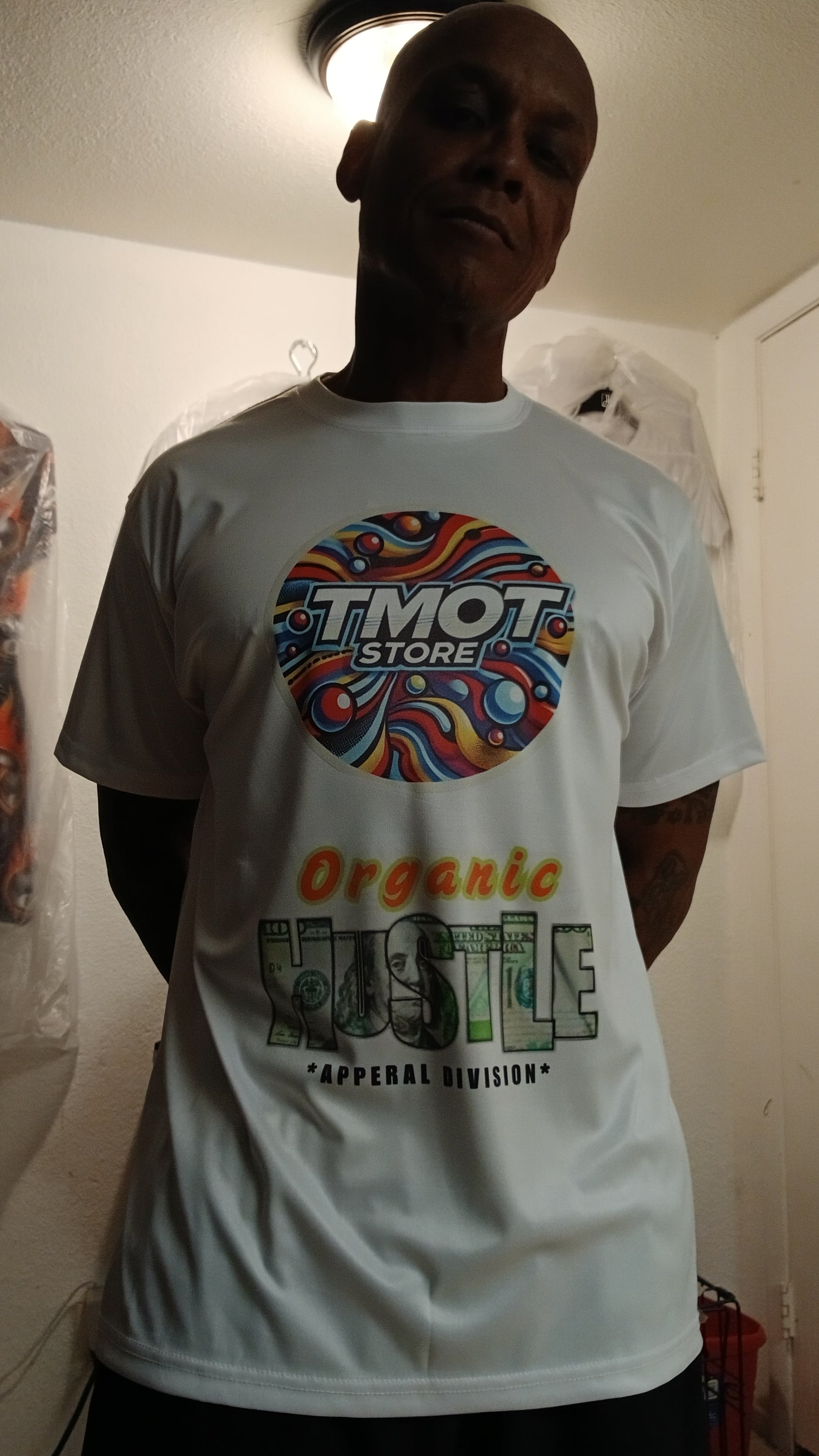 Person wearing a white t-shirt with colorful graphics and text.